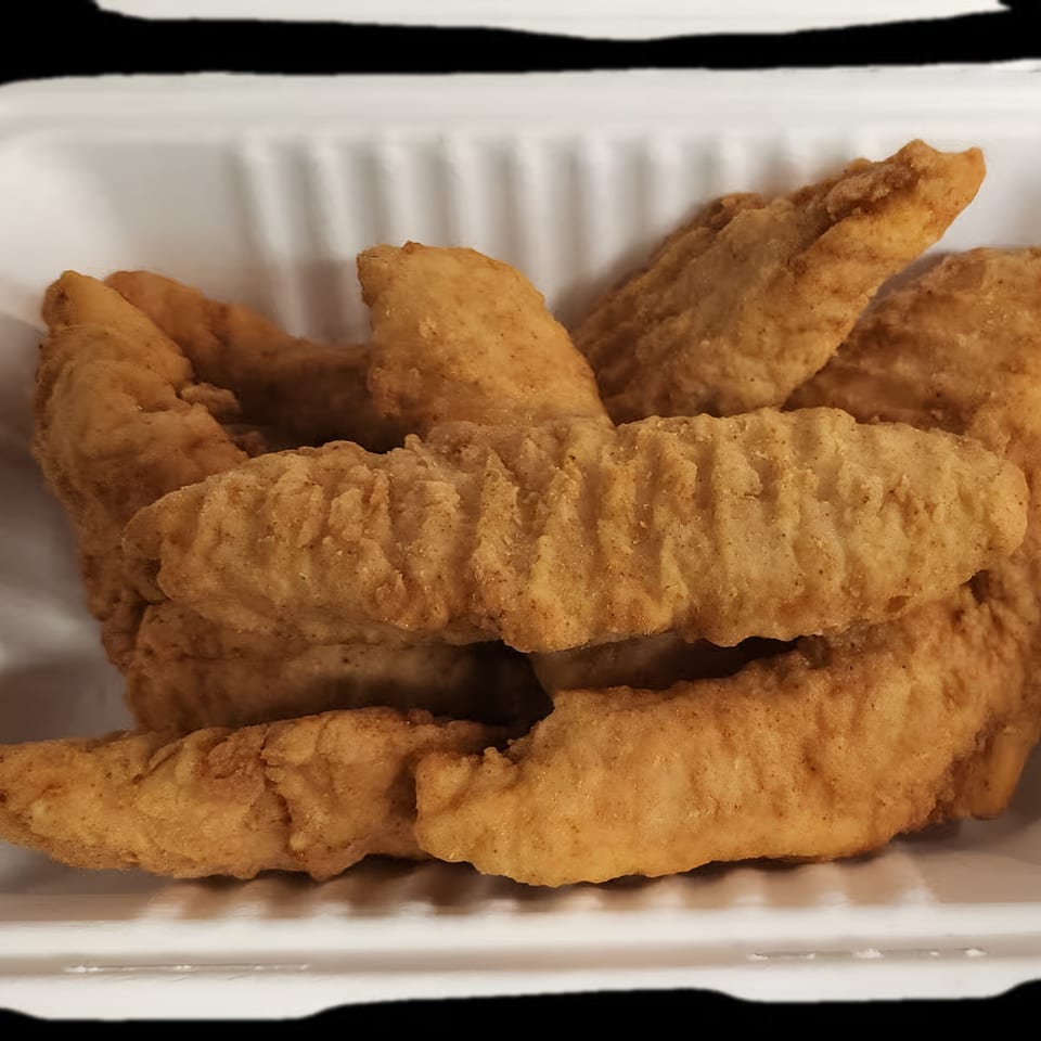 Crispy, golden-brown chicken tenders in a white takeout container from Eastside Market.